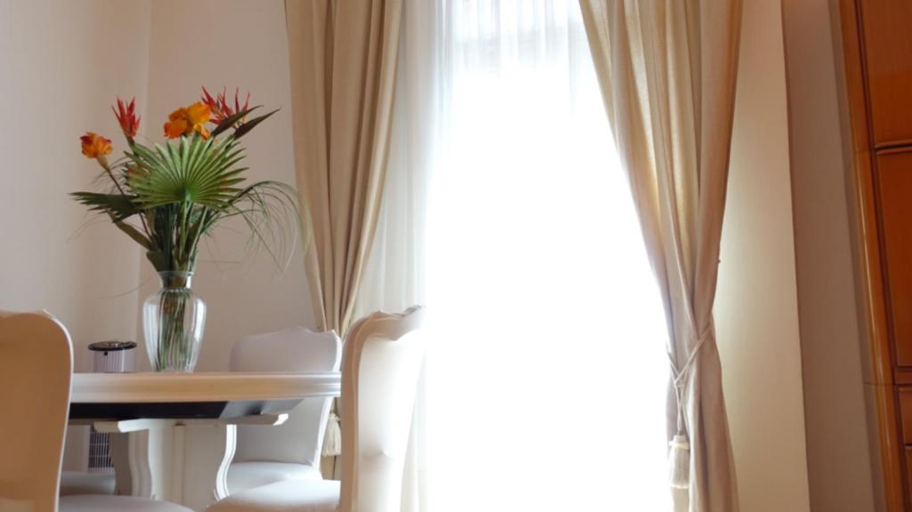 un vaso di fiori seduto su un tavolo accanto a una finestra di Appartamento da Marietta a Tivoli Terme