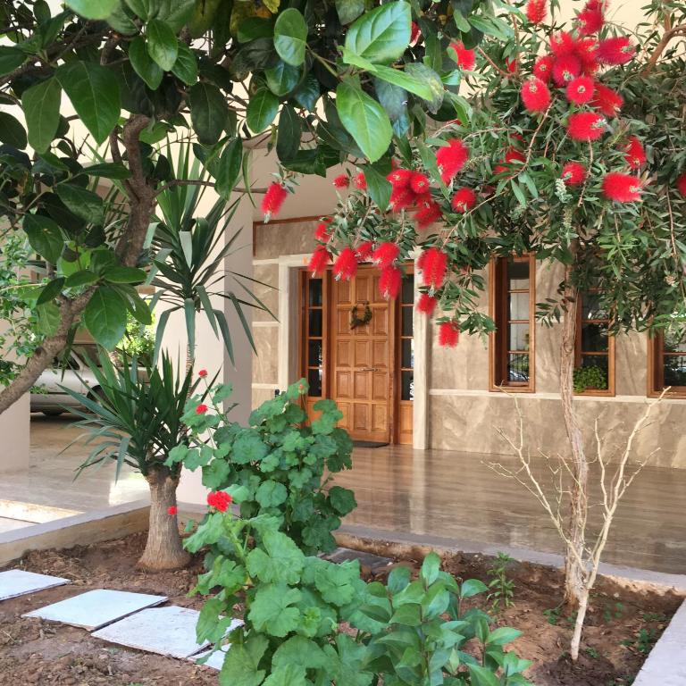 um edifício com flores vermelhas em frente em Camelia Apartment em Nafplio