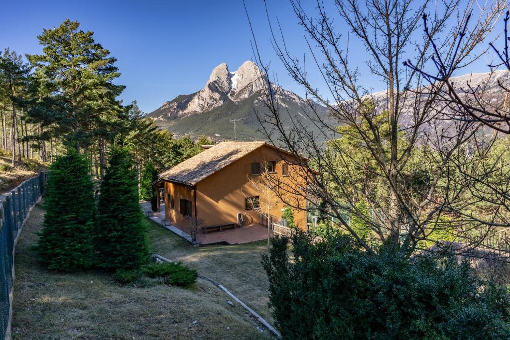 una pequeña casa con una montaña en el fondo en Cal Roig - Pedraforca, en Saldes