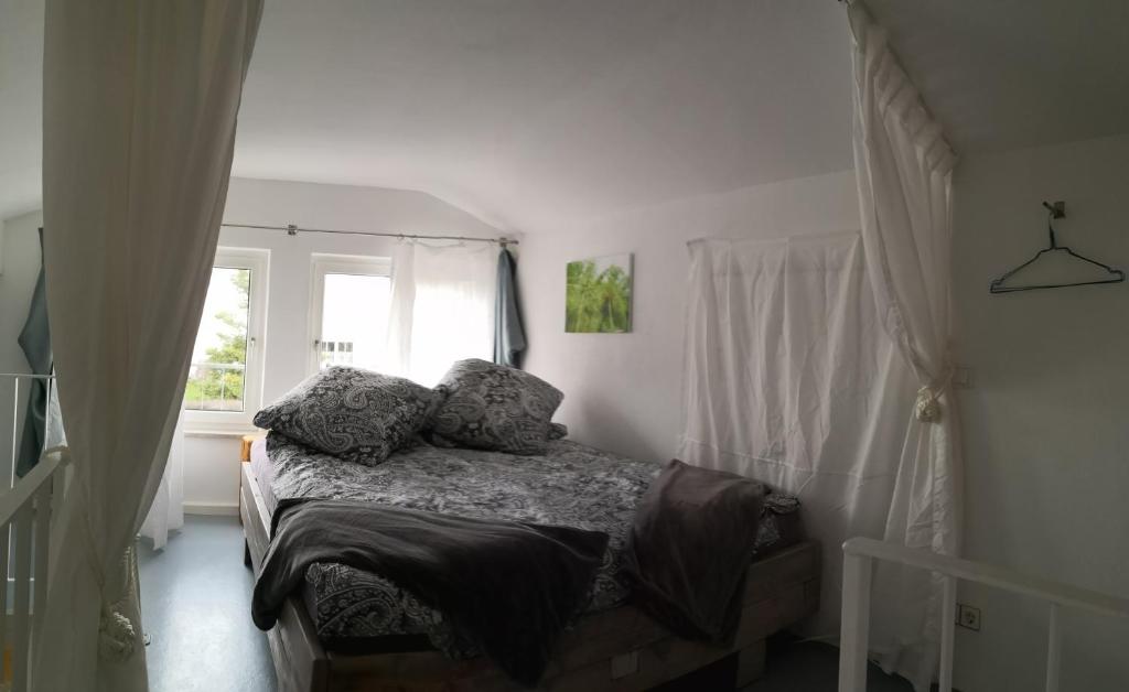 1 dormitorio con cama con almohadas y ventana en Sunny Loft Haus RV en Ravensburg