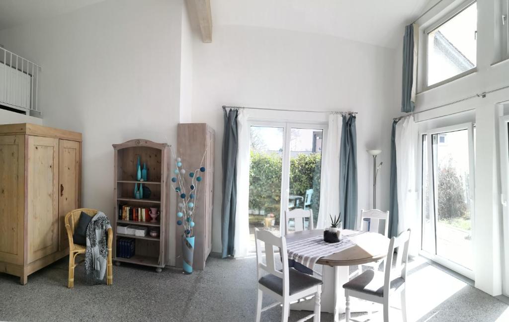 a white dining room with a table and chairs at Sunny Loft Haus RV in Ravensburg