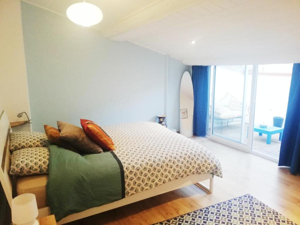 une chambre avec un lit et une grande fenêtre dans l'établissement Duplex Denim, à Nîmes