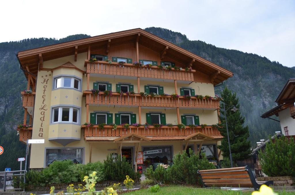 a large building with a balcony on a mountain at Hotel Ladina in Campitello di Fassa