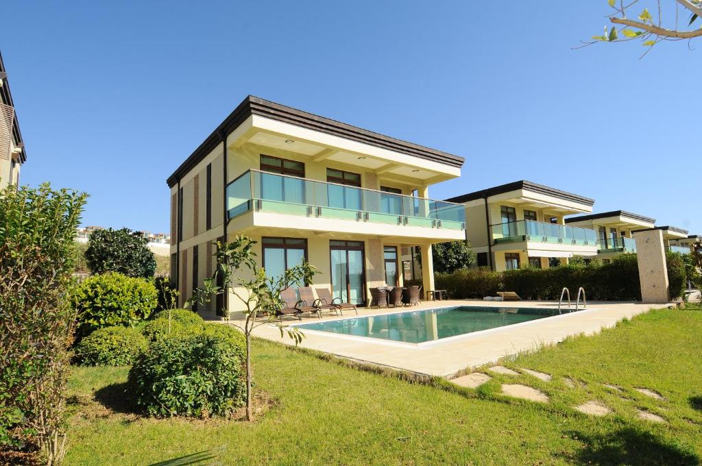 a house with a swimming pool in front of it at Gold City Premium Private Pool Villa with Free Aqua Park in Alanya