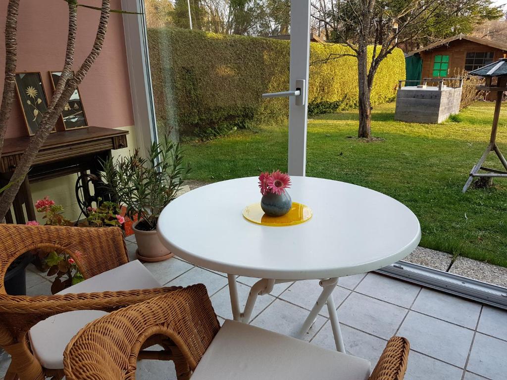 una mesa blanca con un jarrón en un patio en Doris & Michael en Penzberg