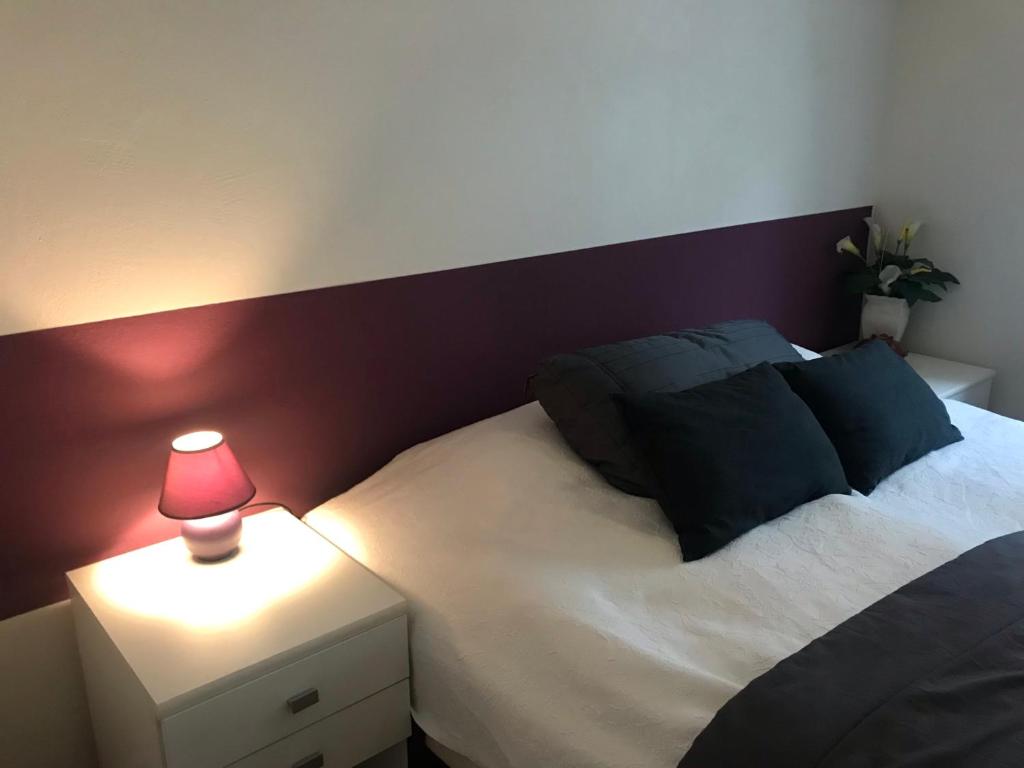 a bedroom with a bed with a lamp on a night stand at Padborg Hotel in Padborg