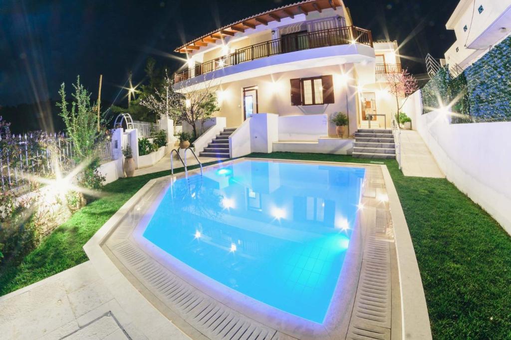 a swimming pool in front of a house at night at Villa Irina in Míloi