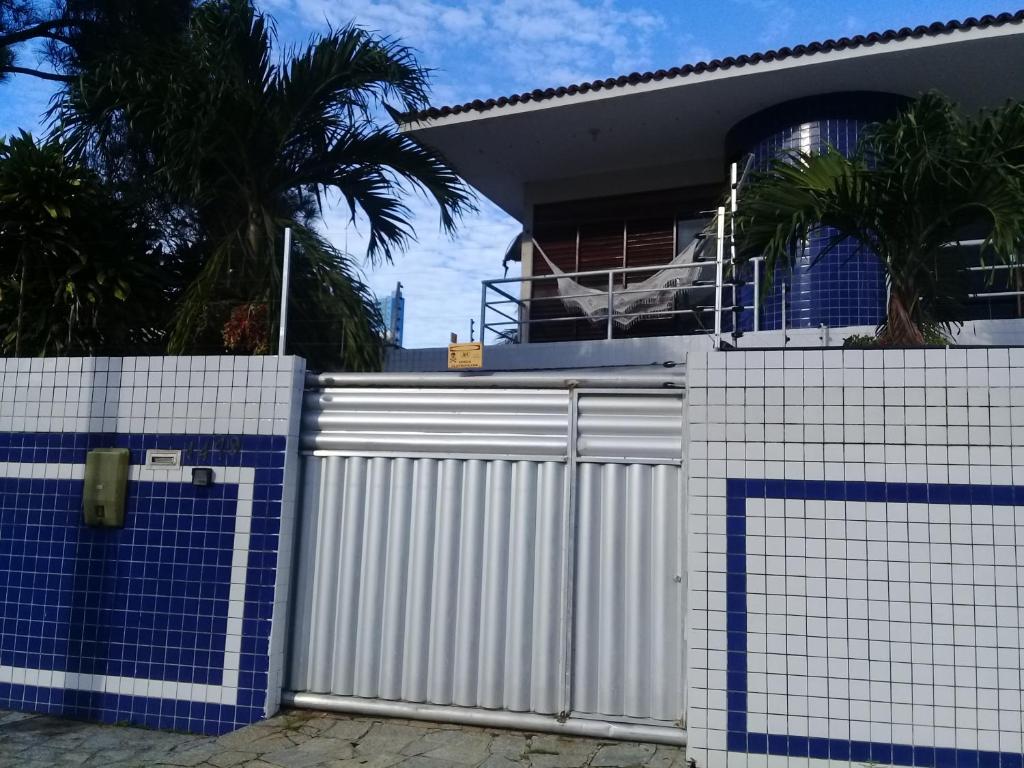 una cerca blanca frente a una casa en Sua casa fora de casa en João Pessoa