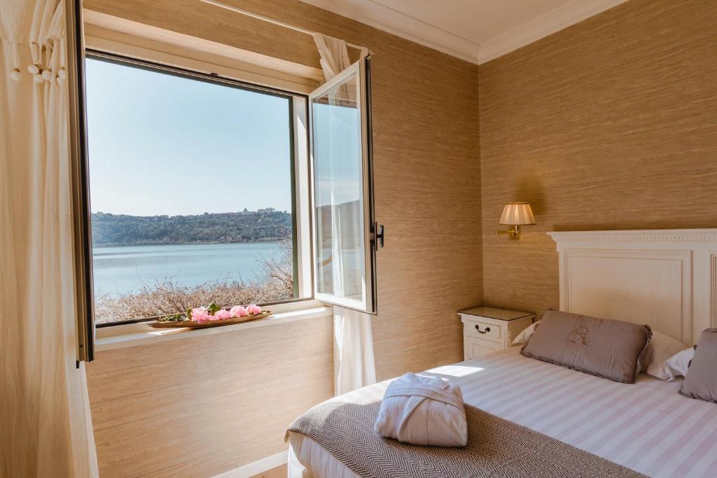 sypialnia z łóżkiem i dużym oknem w obiekcie Hotel La Culla Del Lago w mieście Castel Gandolfo