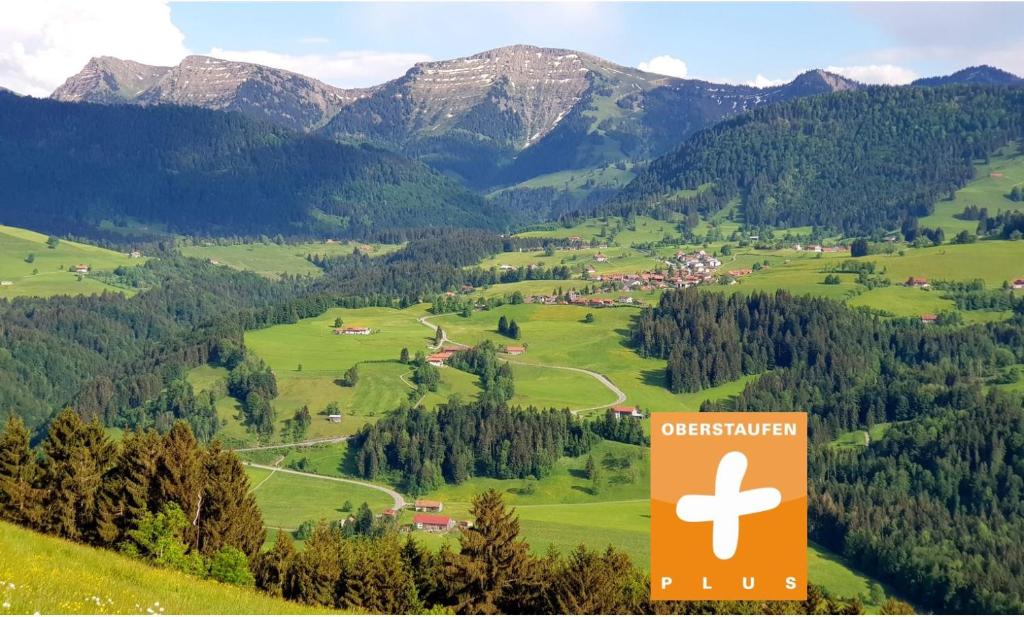 una señal en medio de un valle con montañas en Ferienwohnungen am Schlossberg Oberstaufen, en Oberstaufen