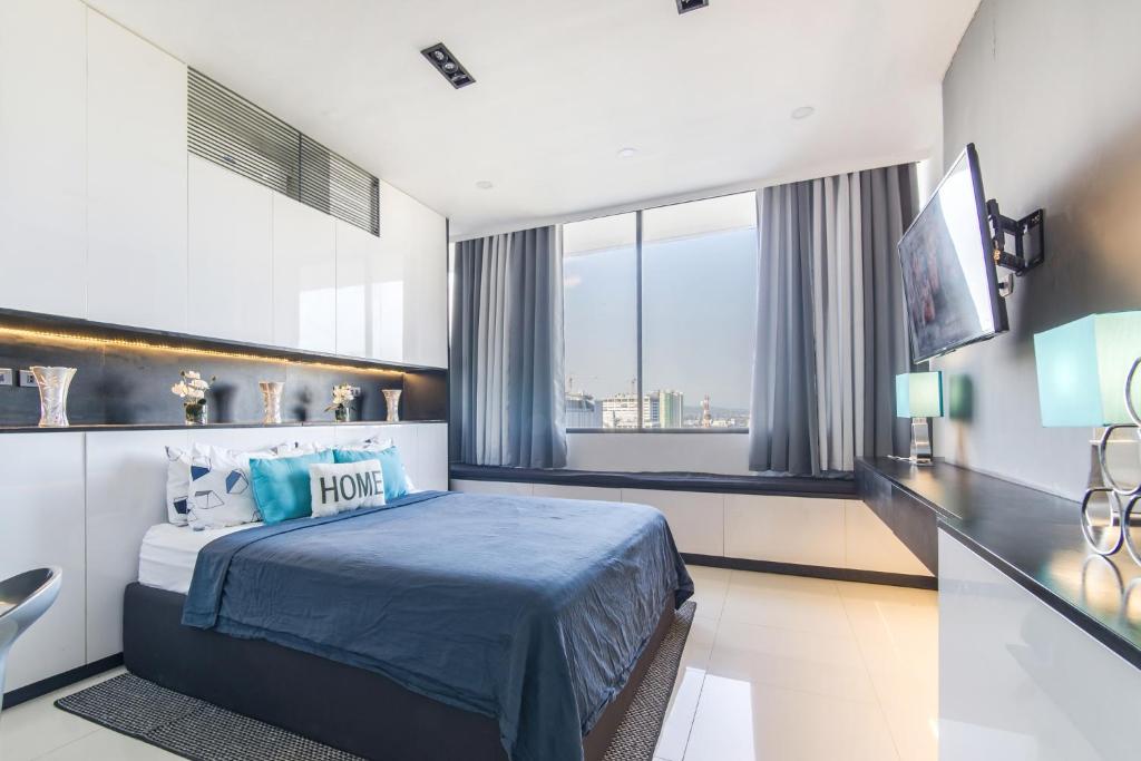 a hotel room with a bed and a large window at FREE Netflix Condo near IT Park with 32-inch Samsung HDTV in Cebu City