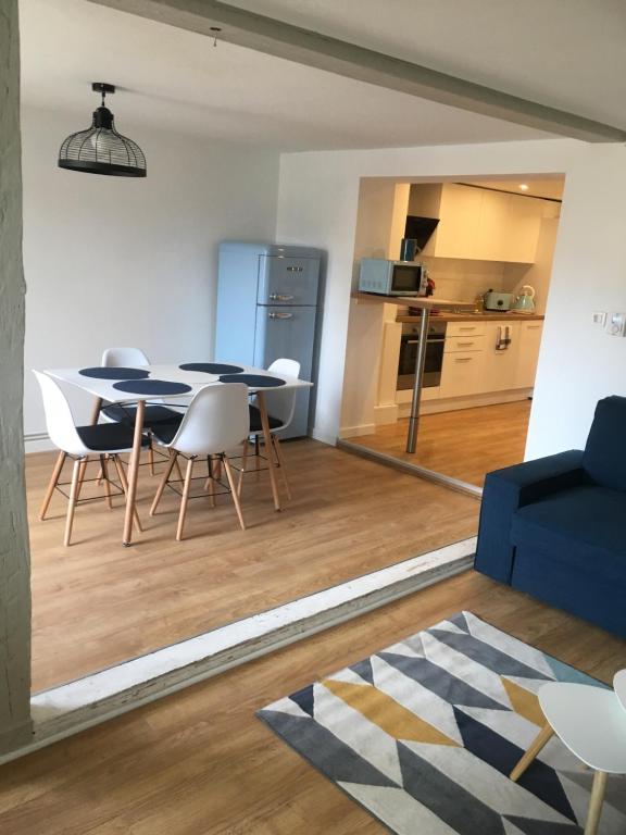 a living room with a table and chairs and a kitchen at Les Appartements de Home Petite Venise in Colmar