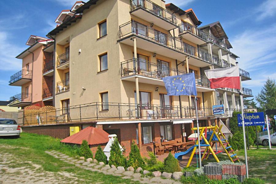 a large building with flags in front of it at Baltic Neptun in Jastrzębia Góra