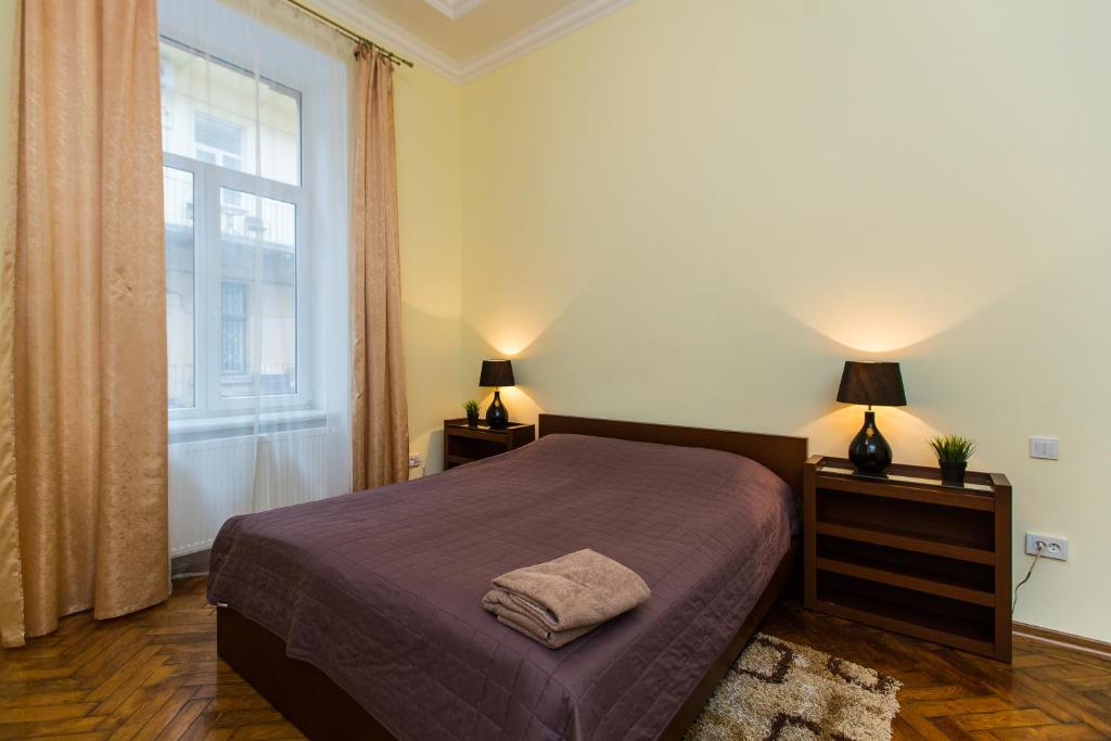 um quarto com uma cama e uma janela em 3 rooms apartments in the city centr em Lviv