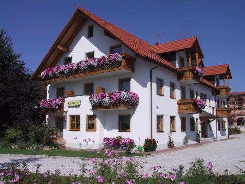 ein großes weißes Gebäude mit Blumenkästen drauf in der Unterkunft Hotel garni Hopfengold in Wolnzach