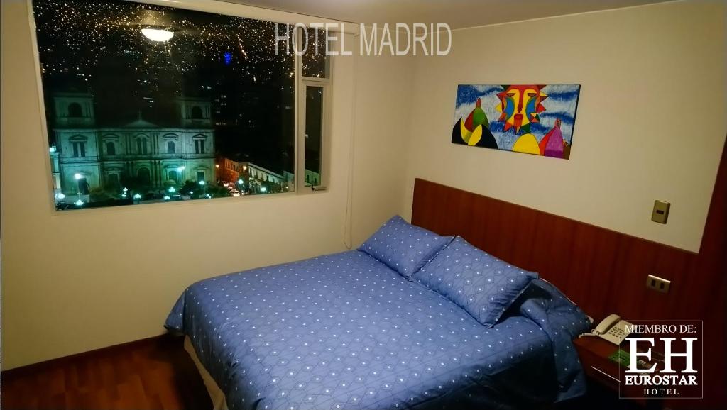 a bedroom with a blue bed and a window at Hotel Madrid in La Paz
