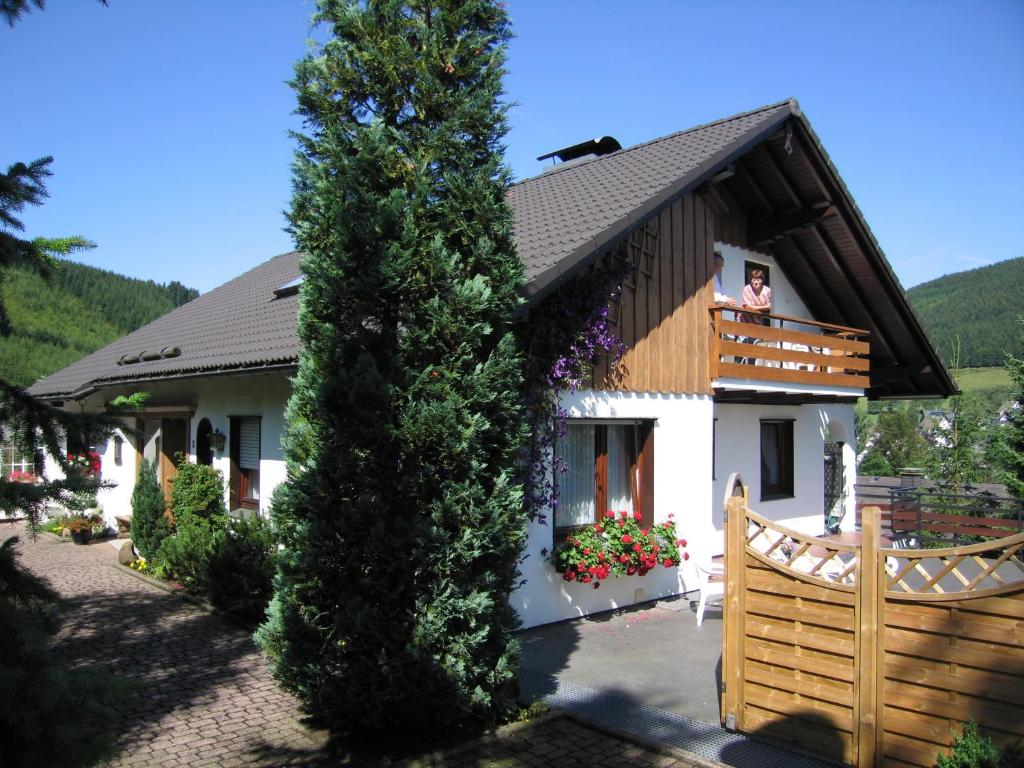 a woman standing on the balcony of a house at Ferienwohnung Bücker in Schmallenberg