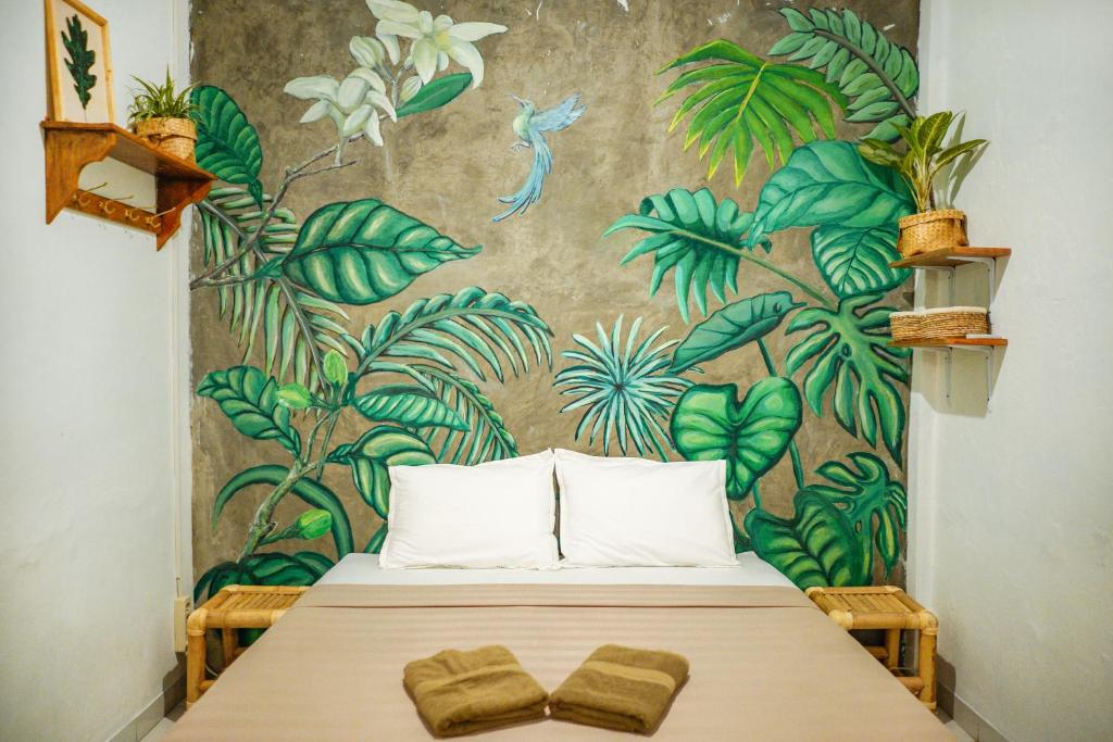 a bedroom with a bed with a mural of plants at Snooze in Yogyakarta