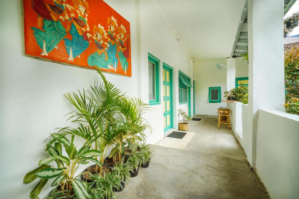 a hallway with plants and a painting on the wall at Snooze in Yogyakarta