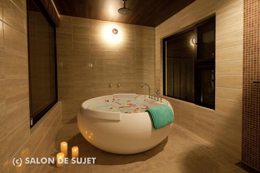 ein Badezimmer mit einer Badewanne mit Konfetti in der Unterkunft Bougain Terrace Resort Ta-chi House in Nago