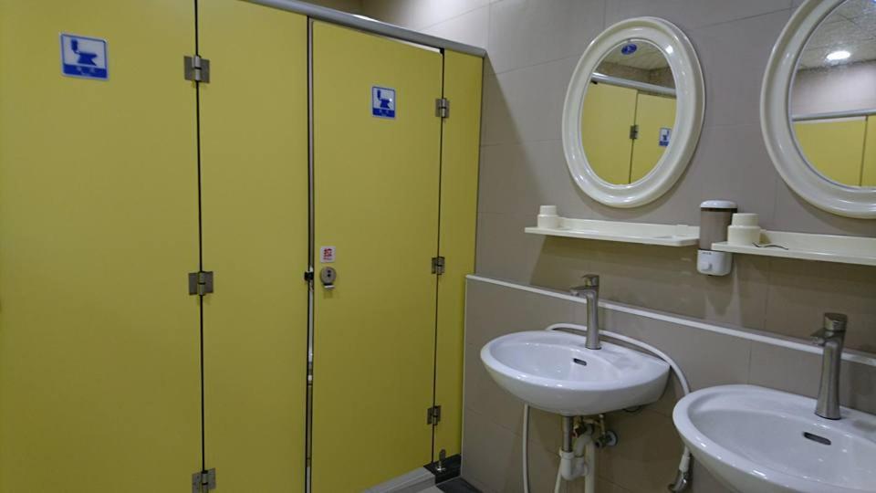 a bathroom with two sinks and a green partition at Guotai Backpack in Kaohsiung