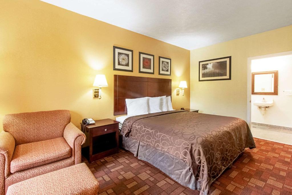 a hotel room with a bed and a chair at Quality Inn & Suites in Dickson