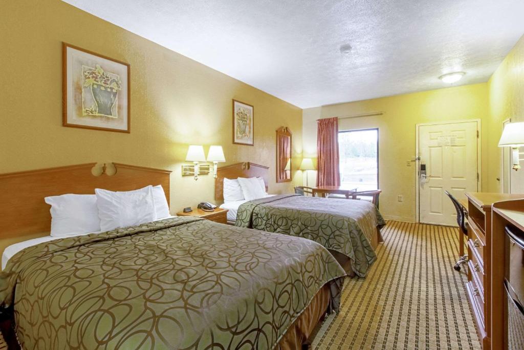 a hotel room with two beds and a bathroom at Quality Inn & Suites in Dickson