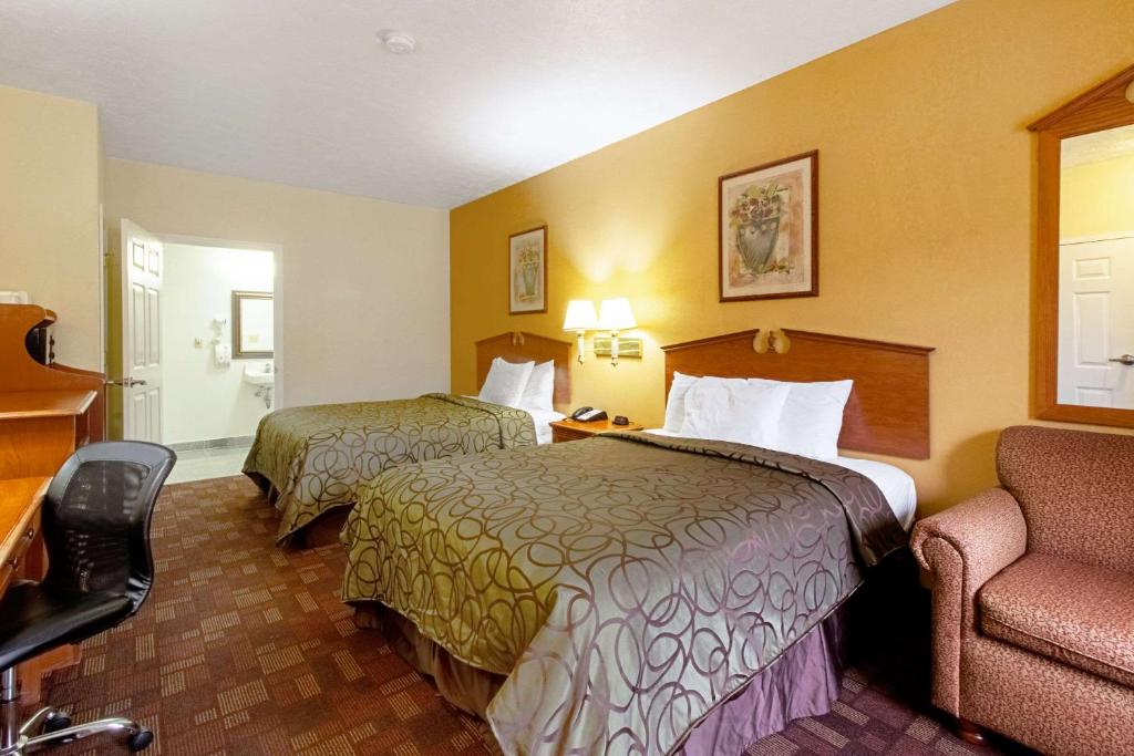 a hotel room with two beds and a chair at Quality Inn & Suites in Dickson