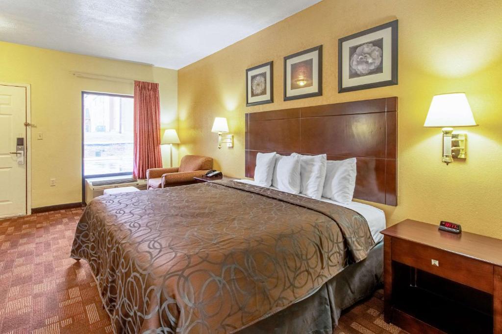 a hotel room with a large bed and a desk at Quality Inn & Suites in Dickson