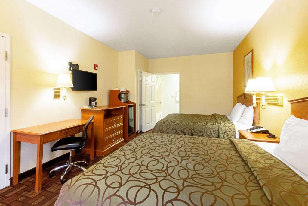 a hotel room with two beds and a desk at Quality Inn & Suites in Dickson