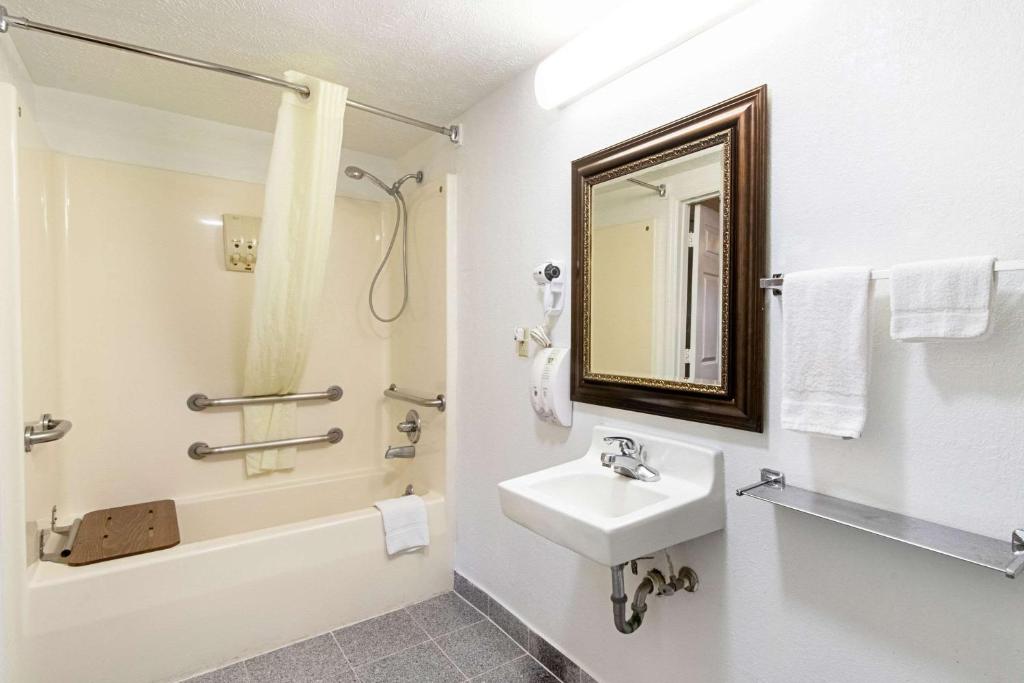 a bathroom with a sink and a tub and a mirror at Quality Inn & Suites in Dickson