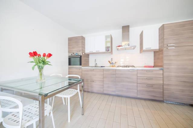 a kitchen with a glass table and white chairs at Casa Grazia Letojanni Centro in Letojanni