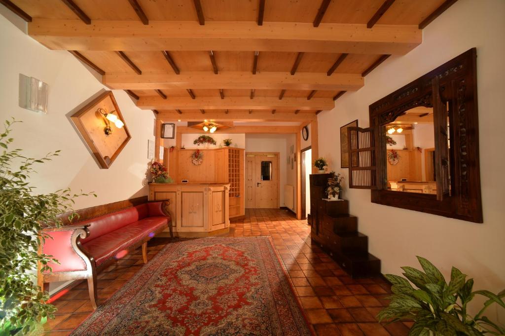 salon z czerwoną kanapą i lustrem w obiekcie Hotel Dalla Serra w mieście Mezzana