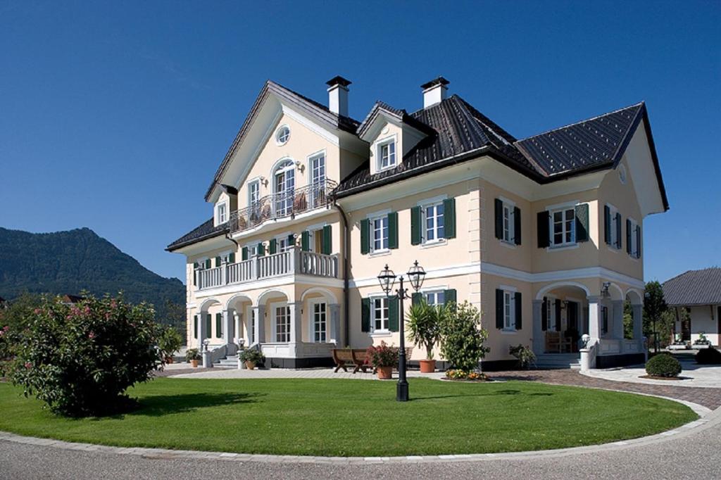 a large white house with a black roof at Privatzimmer Stabauer in Mondsee
