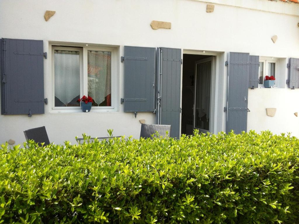 une maison avec volets bleus et fenêtre dans l'établissement La Jarrie Leduc, à La Jarrie