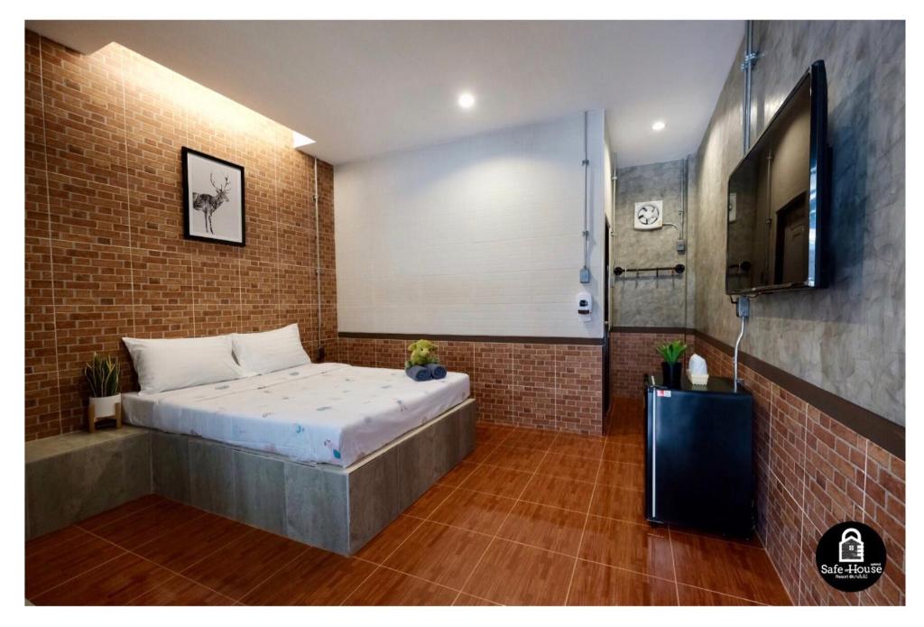 a bedroom with a bed in a brick wall at เซฟเฮ้าส์รีสอร์ท บางใบไม้ in Suratthani