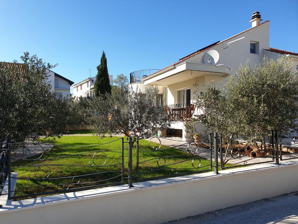 a view of a yard with trees in front of a house at Fyaka Loft Apartments in Vodice
