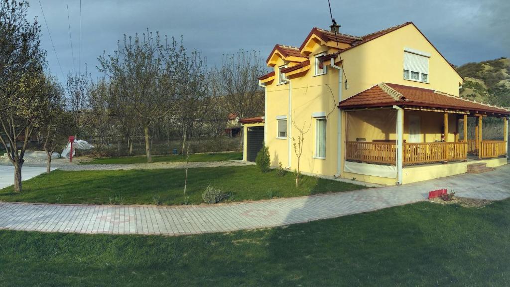 a yellow house with a porch and a yard at Family House Near Motorway 6 Guests 3 Bedrooms in Veles