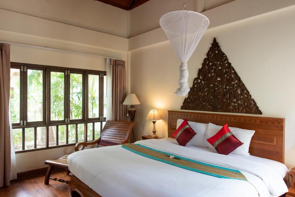 a bedroom with a large bed with a christmas tree on the wall at Royal Lanta Resort & Spa in Ko Lanta