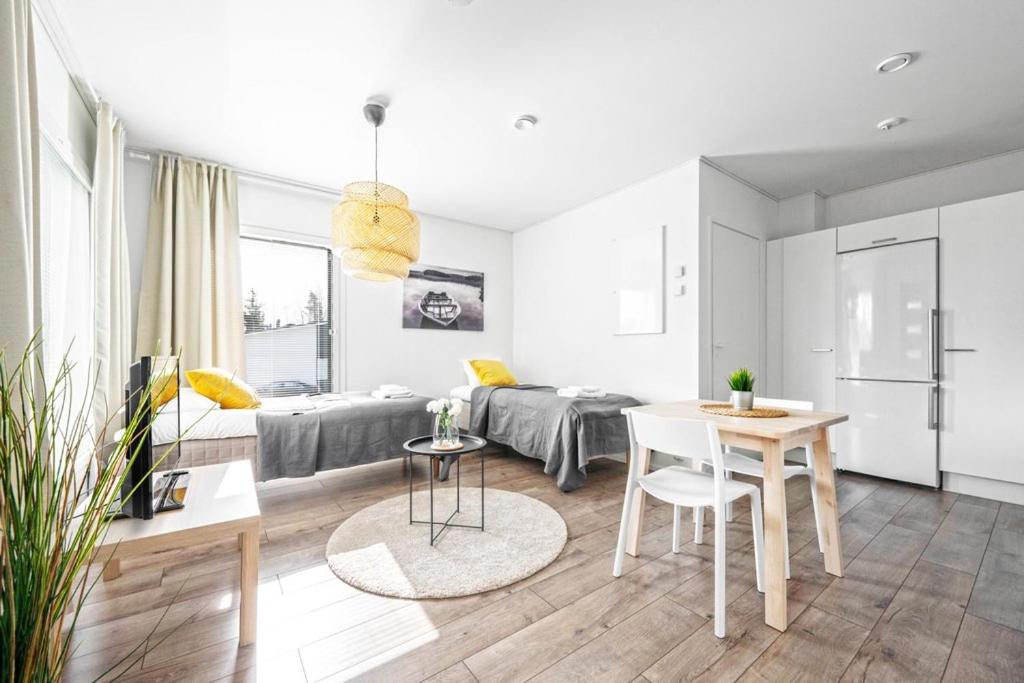 uma sala de estar branca com uma cama e uma mesa em Vihtakatu Apartments em Järvenpää