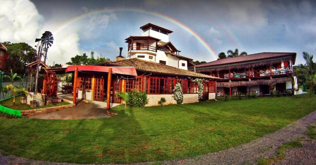 un arco iris en el cielo sobre un edificio en Pousada Maktub, en Guarda do Embaú