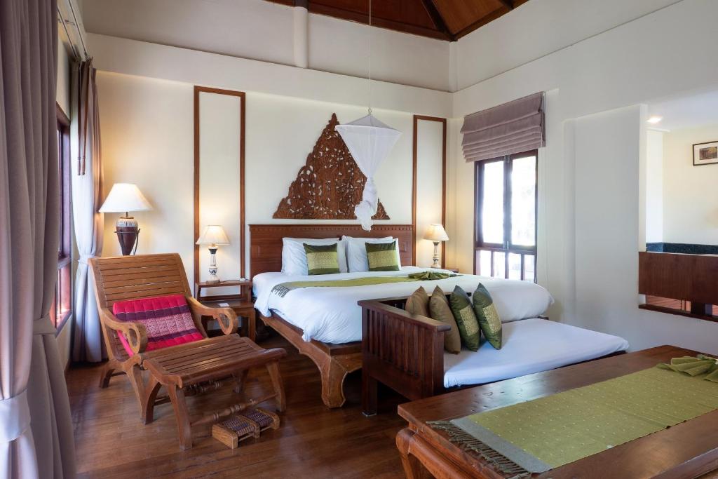 a bedroom with a bed and a table in a room at Royal Lanta Resort & Spa in Ko Lanta