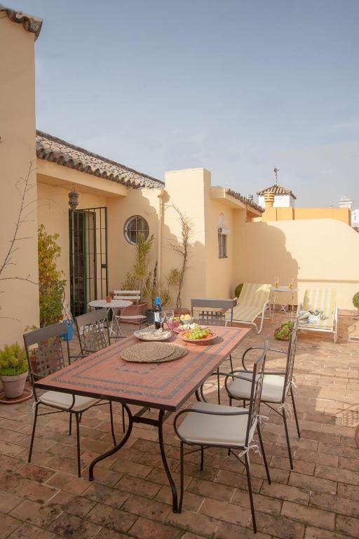 patio ze stołem i krzesłami na ceglanym patio w obiekcie BOTANIC DUPLEX TERRACE 5 PAX w Sewilli