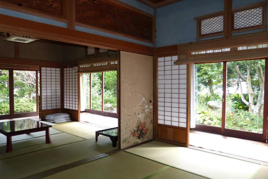 an empty room with windows in a building at Guesthouse Higashi Fujitatei in Shinonsen