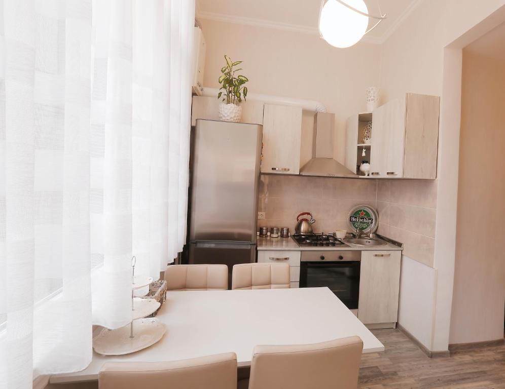 eine Küche mit einem weißen Tisch und Stühlen in der Unterkunft L&L Apartment in Tbilisi City