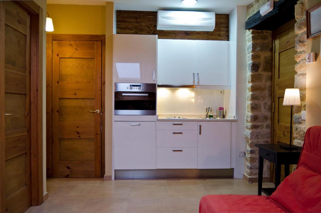 a kitchen with white cabinets and a stove top oven at Apartamentos Playa Galizano in Galizano