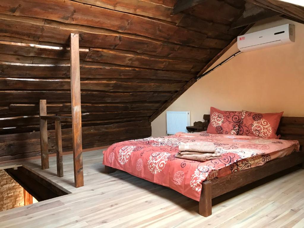 a bed in a room with a wooden ceiling at Two-floor apartments and studio 2-х этажные апартаменты и студия в самом центре in Kharkiv