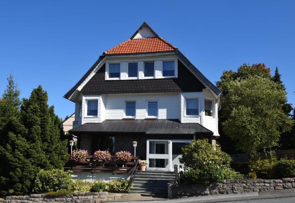 une maison blanche avec un toit rouge dans l'établissement Hotel Wappenhof, à Braunlage