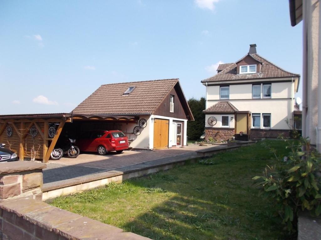 a house with a garage and a red car in it at Ferienwohnung Janne in Fürstenberg