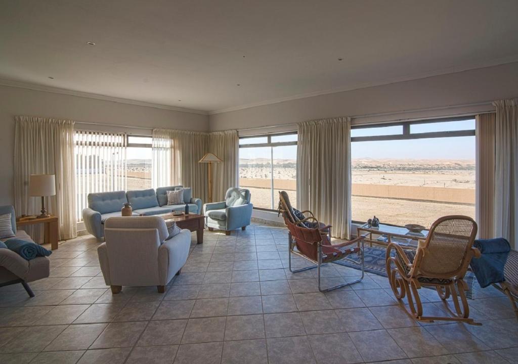 a living room with a couch and chairs and a table at Chala-Kigi Apartments in Swakopmund